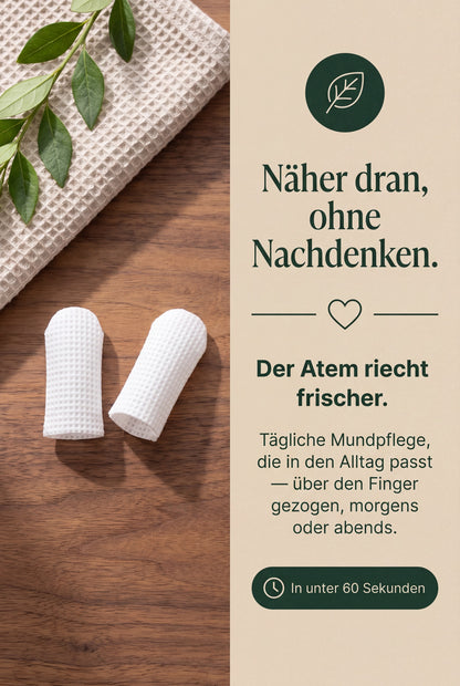 Zwei Malleia Fingerlinge auf Holz neben einem Waffeltuch. Taegliche Mundpflege, die in den Alltag passt
